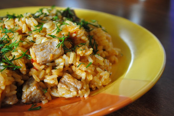 Рис с мясом. Плов на тарелке. Мясо говядины с рисом. Блюдо на кухонном столе
