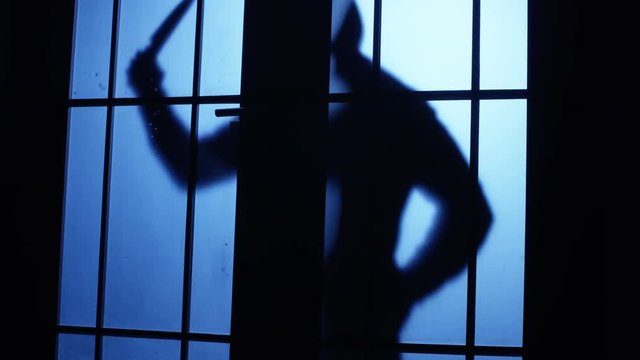 Silhouette of a killer or serial maniac with knife entering to the room but he listen or see anybody and escaping back . Shot on RED EPIC Cinema Camera.