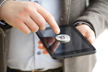 Hand holding smart phone with bitcoin concept on screen.