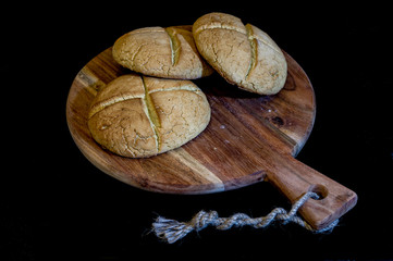panini fatti in casa su tagliere con sfondo nero appena sfornati