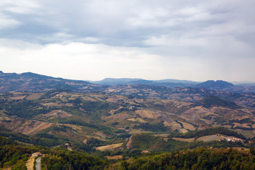 Fototapeta na wymiar San Marino top view. Green meadow. Beautiful panoram of San Marino. Dark heavy sky, Italy.