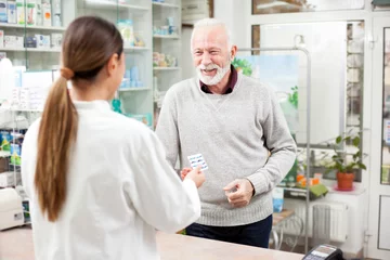 Fotobehang Apotheek Geneeskunde, farmacie, gezondheidszorg en mensenconcept - Gelukkige senior mannelijke klant die medicijnen betaalt bij een drogisterij