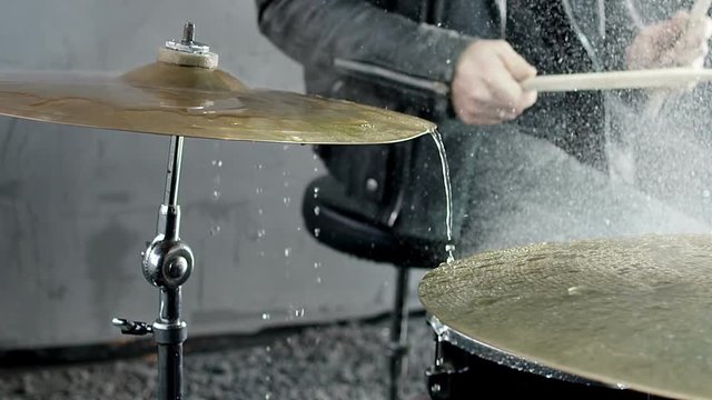 Drummer hitting on wet drum cymbal, and the water splashing from cymbal in slow motion 200 fps. Shot on RED HELIUM Cinema Camera.