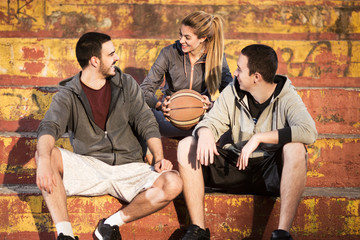 Three basketball players talking and laughing before the game