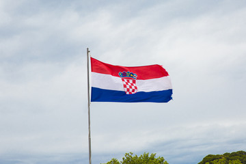 Croatian flag loating with a cloudy sky background