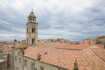 Fototapeta na wymiar Saint Dominic Church bell tower and red roofs of the Dominican Monastery in old town Dubrovnik, Croatia