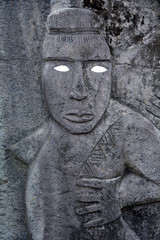 Fototapeta na wymiar Polynesian male figurine rock carving in basalt sculpture