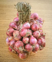 Bunch of Fresh Red Onions on Wooden Table