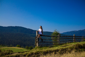 Tourist woman on top of mountains with blue sky. Woman enjoying free happiness in beautiful landscape. Travel concept