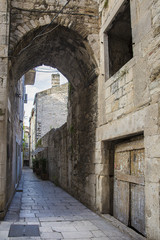 Fototapeta na wymiar cobblestone street with an arch passage in old town Split , Croatia