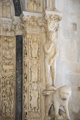 Statue of Adam and a lion at entrance of west portal of saint Lawrence cathedral or Katedrala Sv. Lovre in Trogir, Croatia
