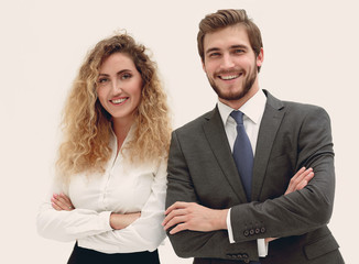 two young business people stand with arms folded