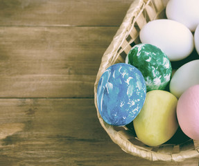 easter basket with colored eggs and place for an inscription on a wooden