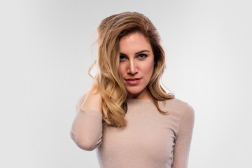 Fototapeta premium Attractive cute blonde. Close-up portrait on a white. Beautiful young woman in a flesh-colored dress.