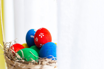 easter and holiday tradition concept - close up shoot of Colored Eggs in Basket