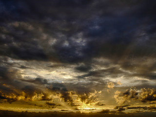 Obraz premium Dramatic sky with sun rays seep through clouds during sunset