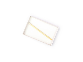 One wooden match with a white head in an open matchbox isolated on a white background. The last match