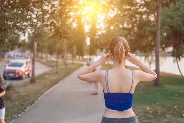 Beautiful young asian woman exhausted from workout running and listen to music, sport women fitness outdoor concept