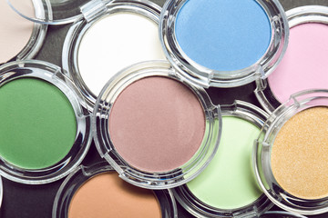 Different eye shadows on dark background. Professional makeup products