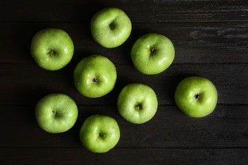 Fresh green apples on wooden background, top view