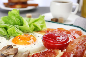 Plate with fried egg, bacon and sauce, closeup