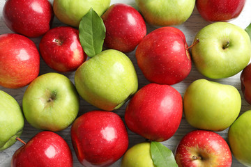 Fresh ripe red and green apples on wooden background, top view
