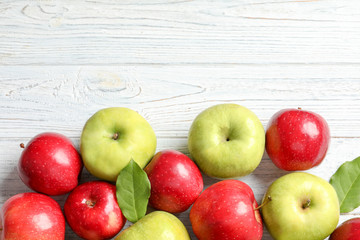 Fresh red and green apples on white wooden background, top view