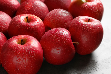 Fresh red apples with drops of water on table, closeup