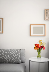 Elegant room interior with beautiful ranunculus and mimosa flowers