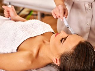 Electronic facial lift massage at beauty salon. Electric stimulation skin care of woman....