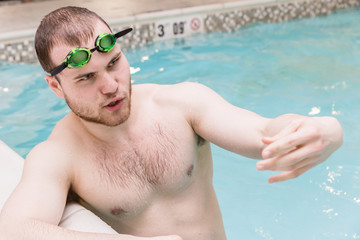 close of young manstanding in pool  and talking.