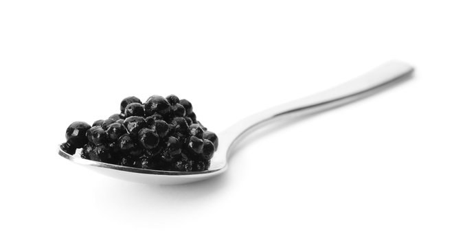 Metal spoon with black caviar on white background