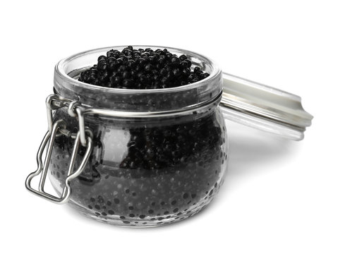 Glass jar with black caviar on white background