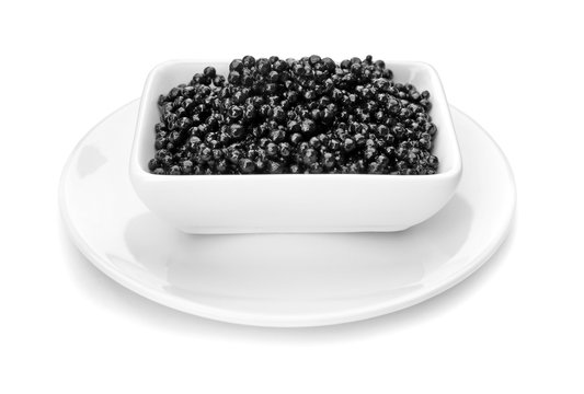 Ceramic bowl with black caviar on white background