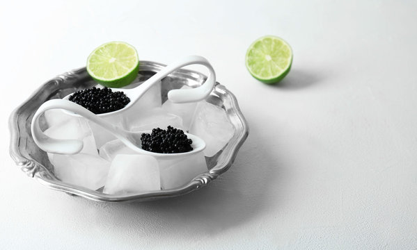 Black caviar served with ice cubes on white background