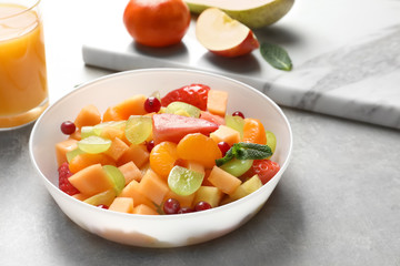 Bowl with fresh fruit salad on table