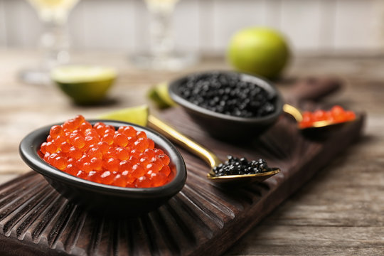 Bowls with black and red caviar on table