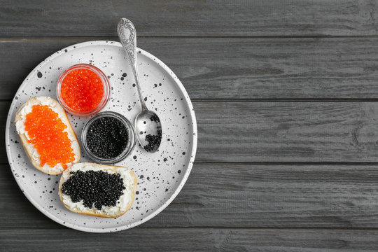 Jars and sandwiches with black and red caviar on plate