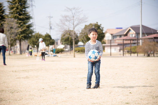 公園でサッカーをする子供