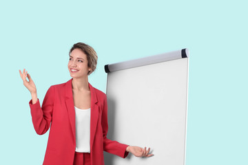 Female business trainer giving presentation on whiteboard against light background