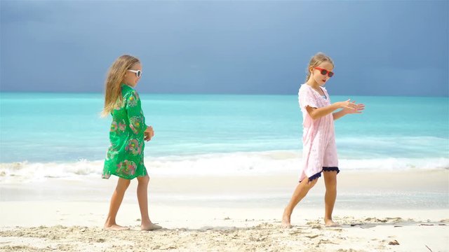 Adorable little girl having a lot of fun at tropical beach playing together