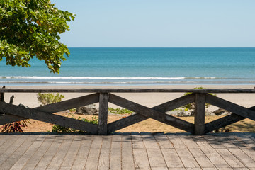 Fototapeta na wymiar wooden terrace with beach, ocean and blue sky background -