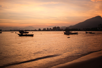 Sunset on the beach and the boats, Caraguatatuba, Brazil.