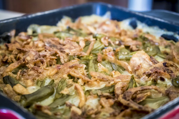 Closeup of a Green Bean Casserole in a Traditional Black and Red Serving Dish