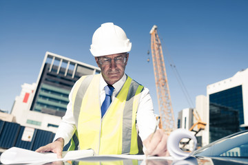 Senior foreman in glasses doing his job at building area on car 