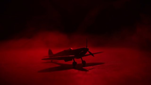 Slider shot. Retro World War 2 propelled model planes in possession.  Dark foggy light background. War scene. Useful for documentary.  Selective focus