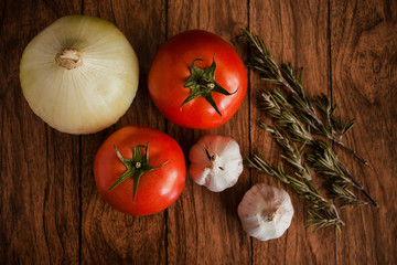 tomatoes, garlic and onion on a wood background close-up 
