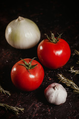 tomatoes, garlic and onion on a black background close-up table top