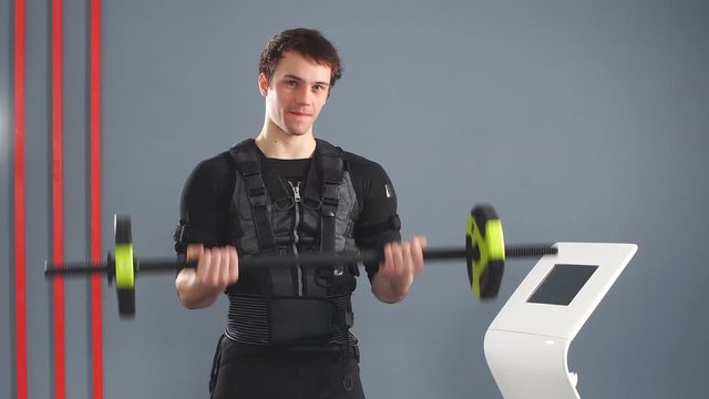 Man wearing EMS costume working out with barbell.