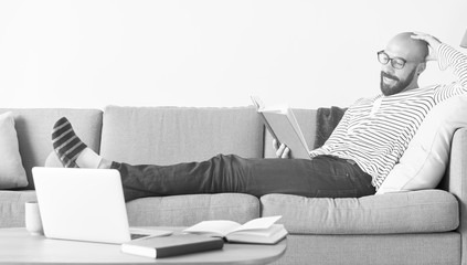 Bearded man reading on the couch